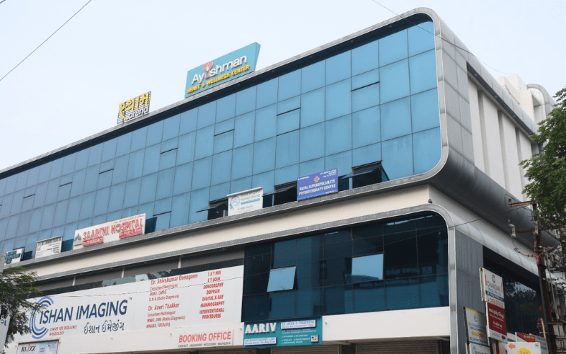 Cardiology Hospital in Vadodara building exterior with Ayushman Heart and Wellness Center, Ishan Imaging, and Sarthi Hospital.
