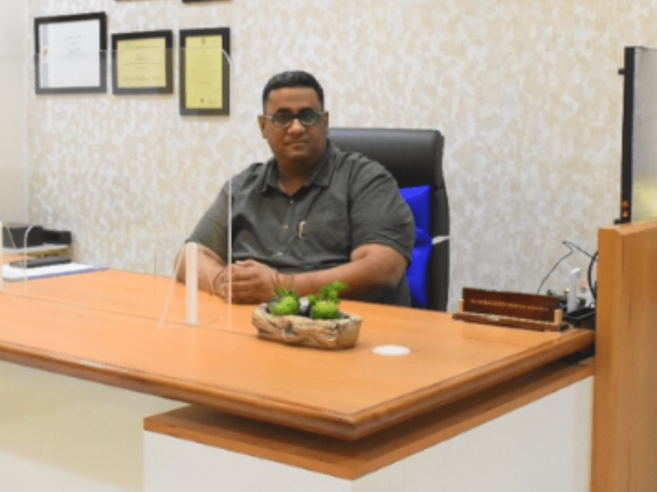 Consultant Interventional Cardiologist sitting at office desk in clinical setup